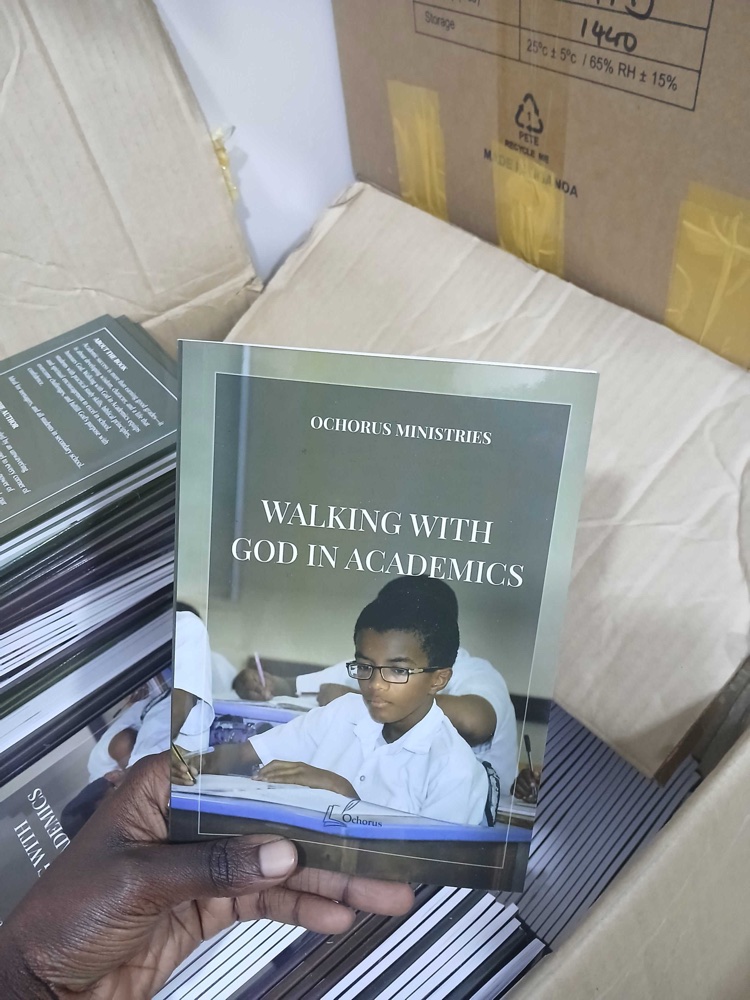 Une main tient un exemplaire imprimé de Walking with God in Academics, publié par Ochorus Ministries